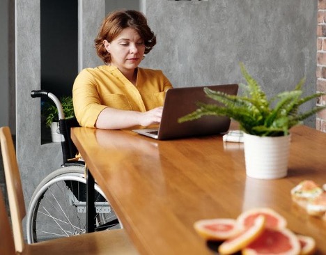 woman-in-yellow-long-sleeve-shirt-sitting-on-chair-in-front-of-brown-wooden-table